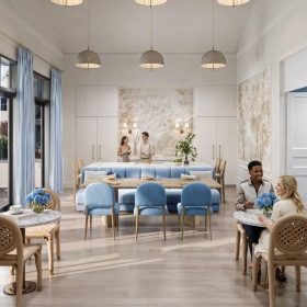 a couple of people sitting at a table in a room with chandeliers