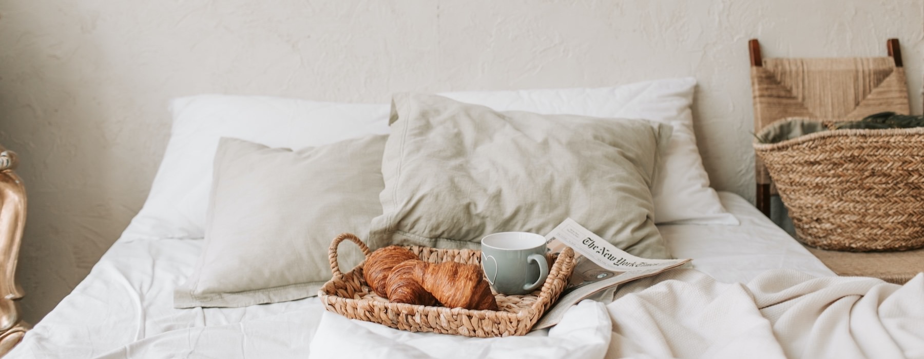 a bed with a cup of coffee and a book on it